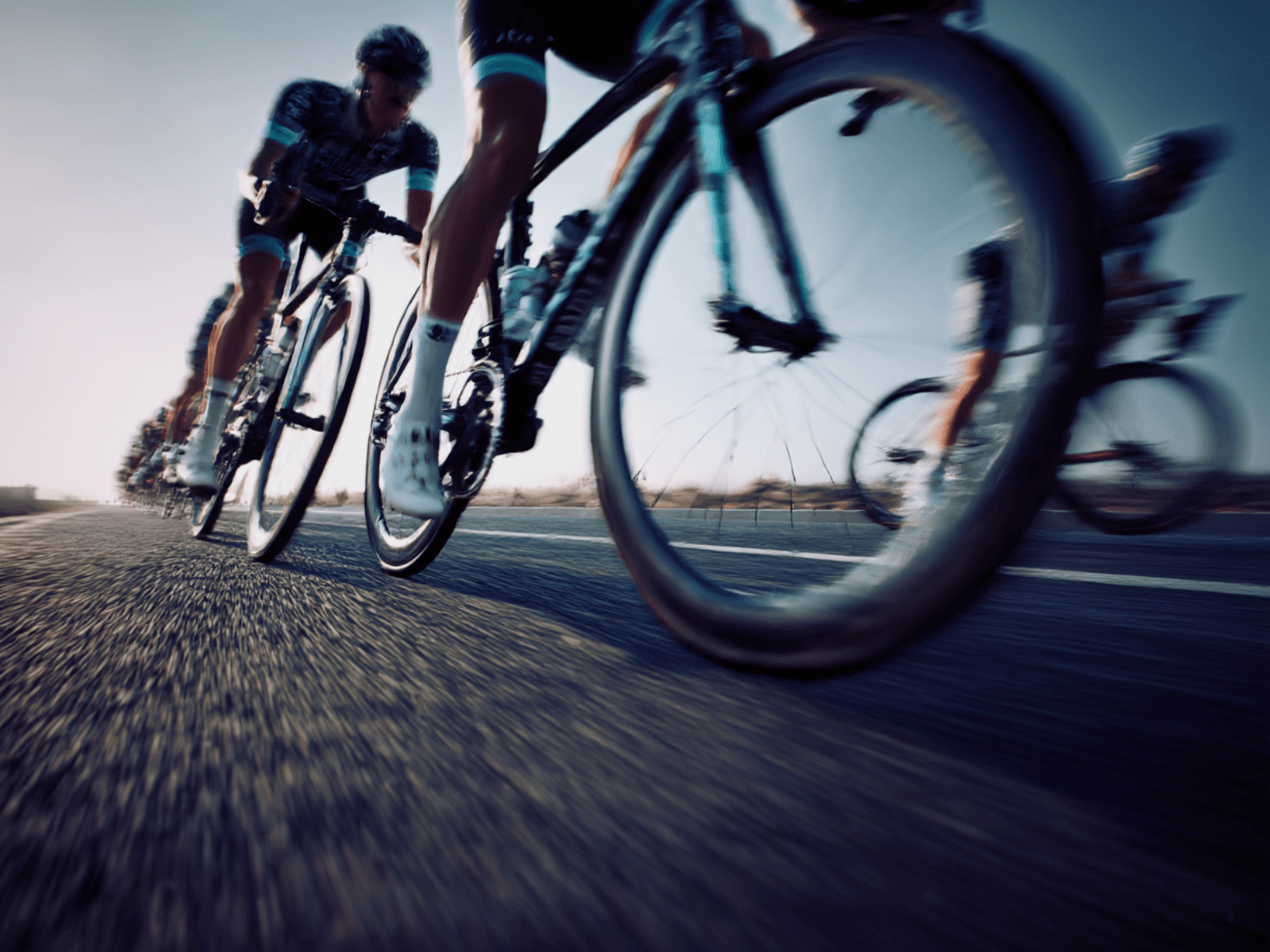 Professional cycling peloton in motion during a WorldTour race, captured with subtle motion blur and neutral tones
